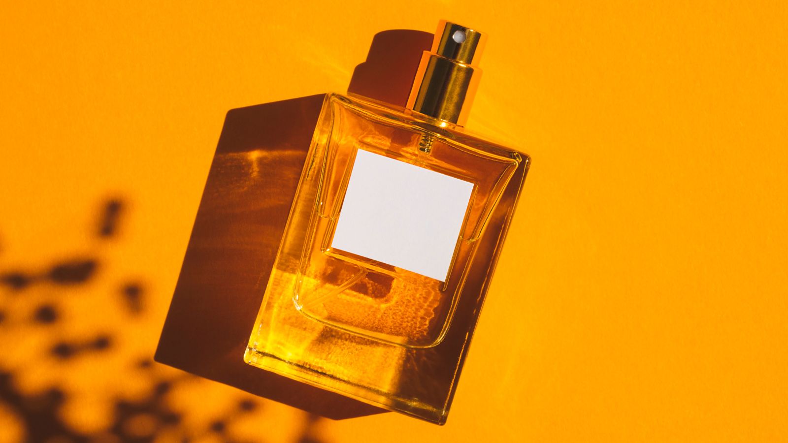 Flakon perfum na pomarańczowym tle